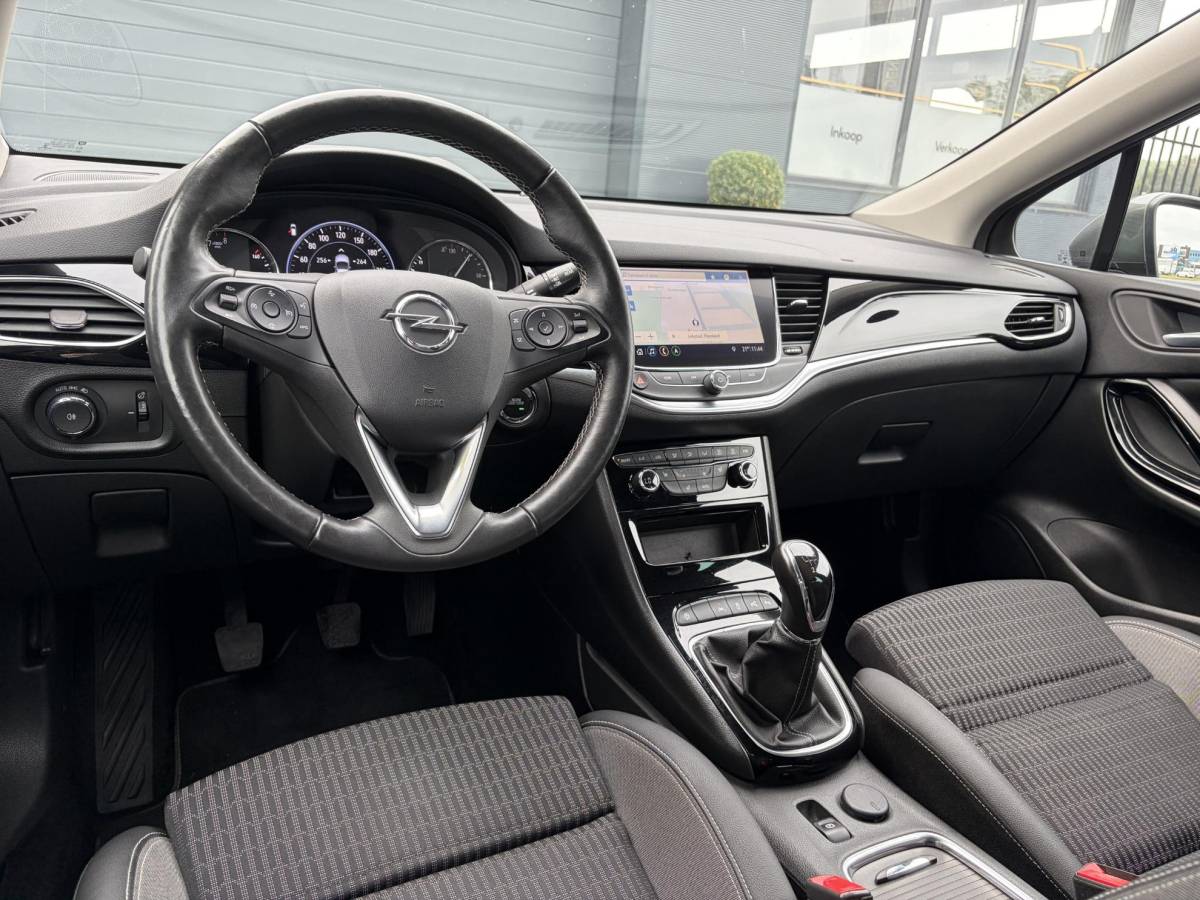 Opel Astra Opel Astra Sports Tourer 1.2 Elegance ✓131pk✓2e Eigenaar✓Camera✓Carplay✓6 Bak✓Stoelverw✓Stuurverw✓Pdc V+A✓Recent beurt gehad✓Clima✓Cruise✓Halfleder✓Keyless✓N.A.P✓Lm velgen✓Rijstrooksensor✓Apk tot 09-2028