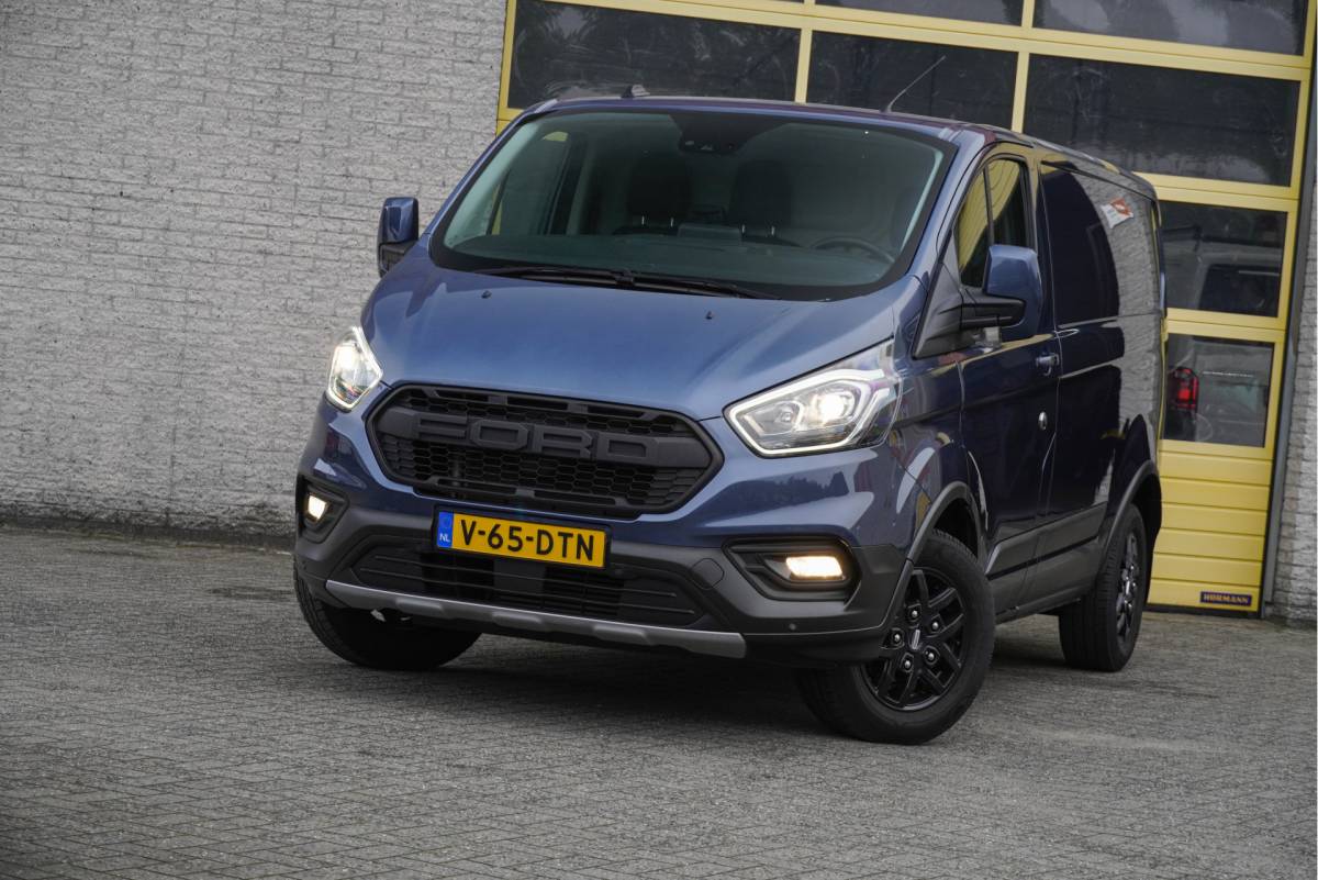 Ford Transit Custom Ford Transit Custom 300 2.0 TDCI L1H1 Trail BJ2022 Lmv 16″ (Zwart) | Led | Pdc | Trekhaak | Verwarmde voorruit | Achteruitrijcamera | Navi | Airco | Cruise control | Lederen bekleding | Verwarmde voorstoelen | Tussenschot | Achterdeuren | Zijdeur | Bijrijdersbank|3 Persoons